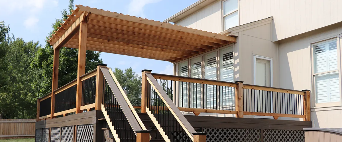 An elevated deck with railings and a pergola