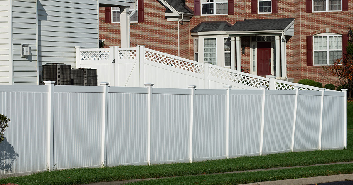 A privacy fence with white vinyl panel boards