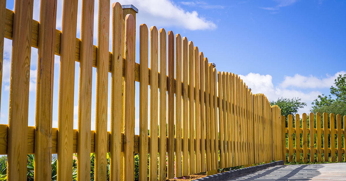 Close up to a small picket fence made of wood