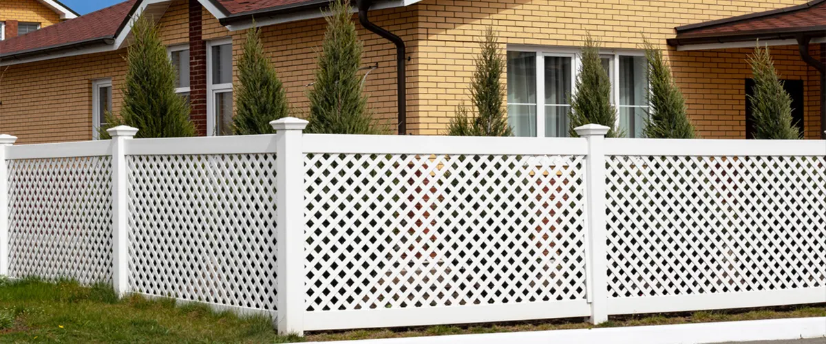 White fence and yellow house