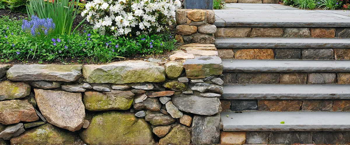 A small stone wall stairs and flowers