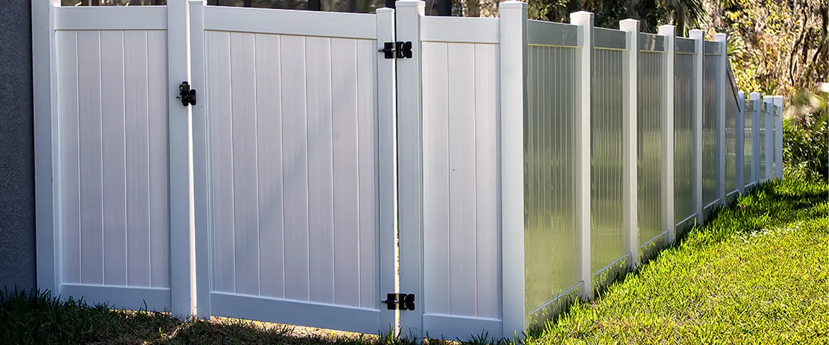 A white vinyl fence for a backyard fencing project