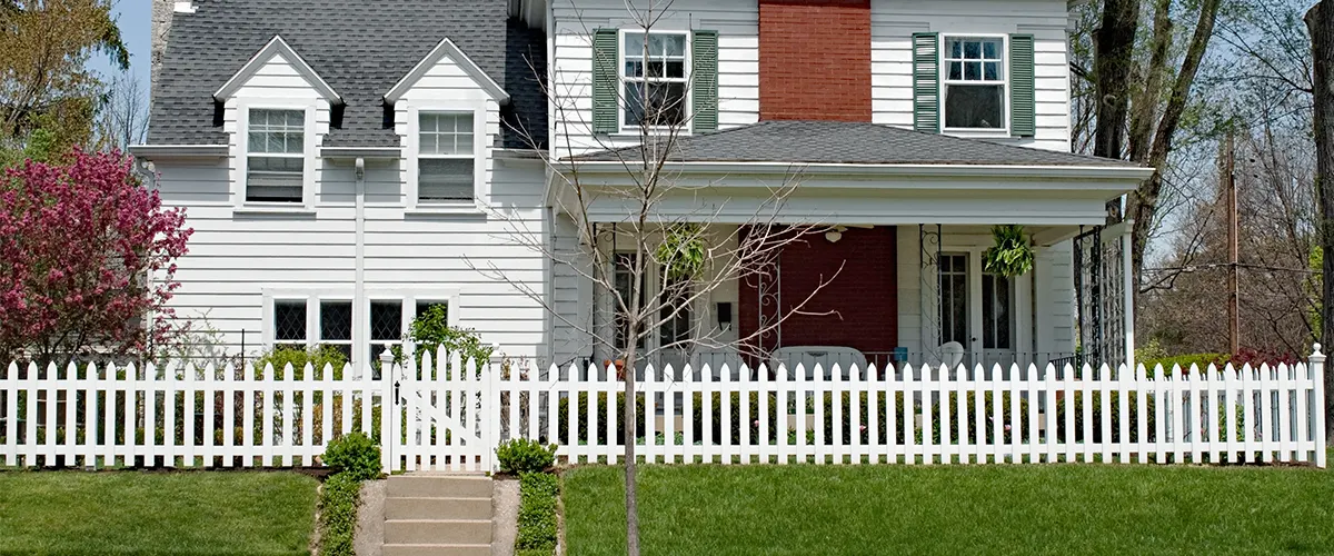 Small picket fence in front of big home