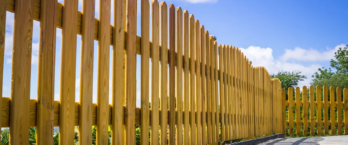 A wooden fence with evenly spaced pickets