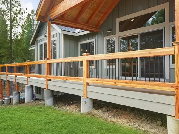Large wooden deck with metal railing attached to house